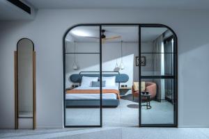 une chambre avec un lit bleu et un miroir dans l'établissement Harmony Boutique Resort - Adults oriented, à Georgioúpoli