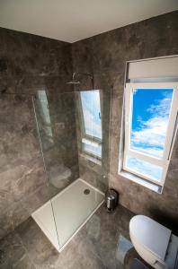 a bathroom with a shower and a toilet and a window at Black Diamond in Novalja +38 photos