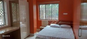 une chambre avec des murs orange et un lit avec deux oreillers dans l'établissement Prime Inn Guest House, à Agartala
