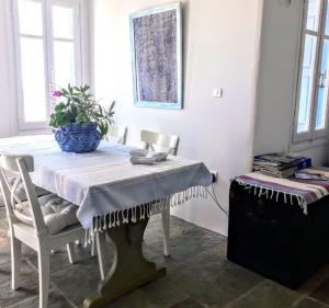 a dining room table with a blue vase on it at Maridina House in Livadi