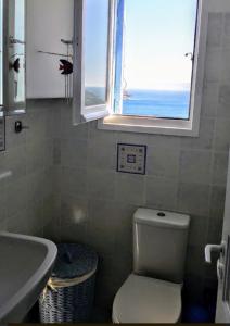 a bathroom with a sink and a toilet and a window at Maridina House in Livadi