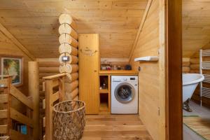 a bathroom with a washing machine in a log cabin at Haus Dorine in Fužine - Haus für 6 Personen in Fužine