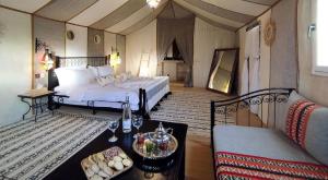 a large bedroom with a bed and a couch at Erg Chebbi Luxury Camp & Activities in Merzouga