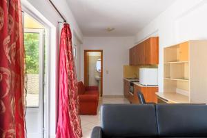 a living room with a couch and a kitchen at D&A Alex Studios in Papoutsíras +4 photos