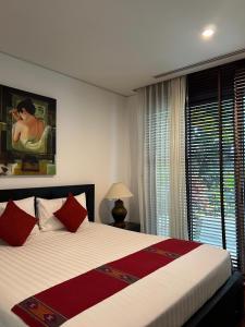 a bedroom with a large bed with red pillows at Kata Gardens Luxury Apartment 8B at Kata Noi Beach in Kata Beach