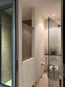 a bathroom with a shower and a toilet and a glass door at Kata Gardens Luxury Apartment 8B at Kata Noi Beach in Kata Beach
