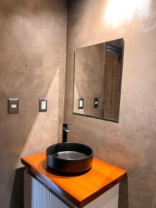 a bathroom with a black sink on a wooden counter at suite campestre con terraza in Puerto Varas +6 photos