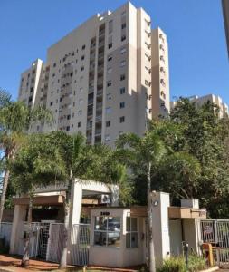 a large white building with palm trees in front of it at Lindo Completíssimo Ap 2 quart Cama King Maq Lavar in Ribeirão Preto +25 photos