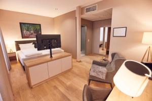 ein Schlafzimmer mit Bett und ein Wohnzimmer in der Unterkunft Seehotel Maria Laach in Maria Laach
