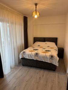 Un dormitorio con una cama y una ventana grande en Apartament 3 camere lux cu terasă - Central Universitatea din Craiova - PARCARE GRATUITĂ, en Craiova