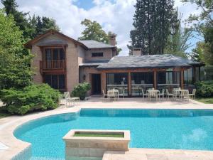 a house with a swimming pool in front of a house at Casa Haydee in Ciudad Lujan de Cuyo