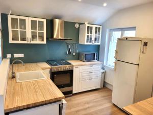 Una cocina con un refrigerador blanco y un fregadero. en Gîte Les Pirouettes, en Pirou