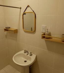 a bathroom with a sink and a mirror at Potrerillos Rio Blanco Tiny, cabaña a orillas del Rio Blanco en Potrerillos in Potrerillos