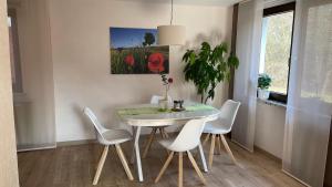 a dining room with a table and white chairs at Ferienwohnung Schwarze in Duderstadt