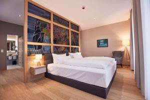 ein Schlafzimmer mit großem Bett und großem Fenster in der Unterkunft Seehotel Maria Laach in Maria Laach + 37 Fotos