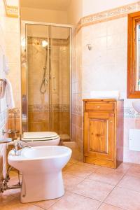 a bathroom with a shower and a toilet and a sink at Villetta con giardino, IUN Q3445 in Cala Gonone +26 photos