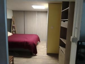 a bedroom with a bed with a red blanket at la maison bonheur in Feytiat