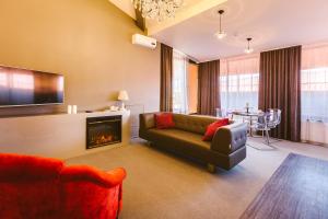 a living room with a couch and a fireplace at Simpatico Apart-hotel Tyumen centre in Tyumen