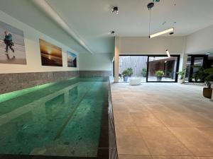 a swimming pool in a house with a large room at Park Welgelegen, bungalow 27 in Cadzand