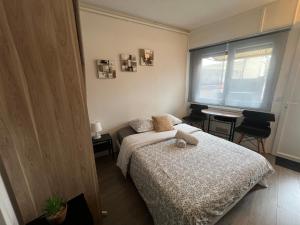 a bedroom with a bed and a table and a window at Studio k Maisons des Examens, ligne 14, Paris in Gentilly