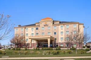a large brick building with a sign on it at Comfort Suites Waxahachie - Dallas in Waxahachie