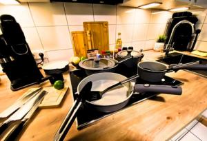 a kitchen with three pots and pans on a stove at Ferienapartment Saarbrücken Zentrumsnah mit Luxus-Heimkino, Grill, Balkon & Miele Küche in Saarbrücken