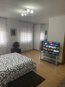 a bedroom with a bed and a flat screen tv at Maravillosa villa con piscina y barbacoa in Puigventos