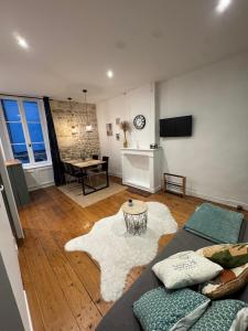 a living room with a couch and a table at ღ Evescot - T2 cosy à deux pas du Vieux-Port in La Rochelle