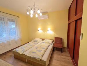 a bedroom with a bed and a chair in it at Holiday home in Balatonlelle 53637 in Balatonlelle