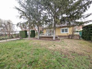 a house with a tree in the yard at Holiday home in Balatonlelle 53637 in Balatonlelle