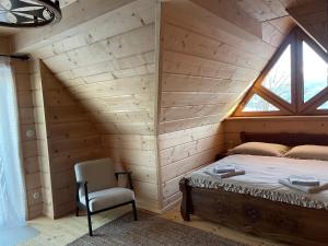 a bed in a room with a window and a chair at Ski&Chill Rafaczówki in Poronin