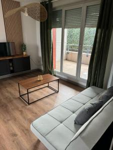 Una sala de estar con un sofá y una mesa de café. en Appartement, Cozy trois, en Toulouse