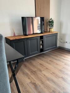 Un televisor encima de un centro de entretenimiento en Appartement, Cozy trois, en Toulouse 3 fotos más