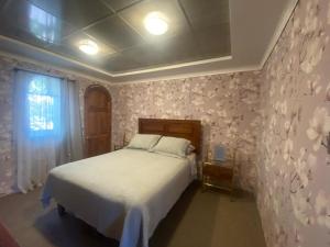 a bedroom with a bed with flowers on the wall at HOSTAL PARIS TALCA in Talca