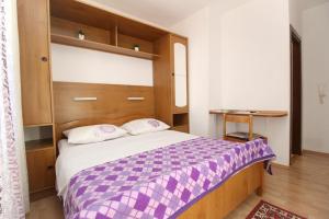 a bedroom with a large bed with a purple blanket at Rooms Grozdana in Baška +15 photos