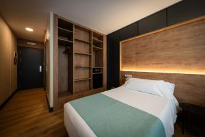 a bedroom with a bed and a book shelf at Hotel Oca Insua Costa da Morte in Cee