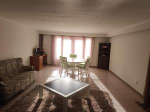 a living room with a couch and a table and chairs at Casa do Outeirinho in Campos