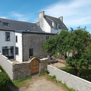 an external view of a house with a stone wall at Maison 14 personnes in Plozévet