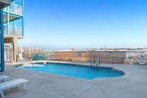 a swimming pool on a patio with a bench at Sundial Unit D1 in Gulf Shores