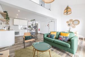 a living room with a green couch and a table at Roots Apartments in Faro