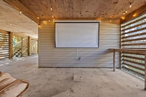 a room with a screen on the wall of a building at Mins to Beach Hot Tub Projector Shuffleboard in Kill Devil Hills