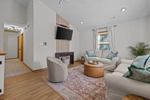 a living room with a couch and a table at Mins to Beach Hot Tub Projector Shuffleboard in Kill Devil Hills +42 photos