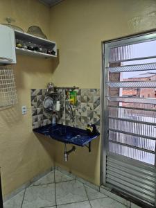 a kitchen with a sink in a room with a window at Terraço sol e lua in Belém