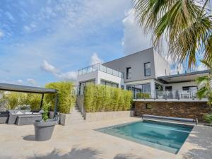 an exterior view of a house with a swimming pool at Luxueuse Villa pour huit personnes, piscine et vue sur le Golf in Juvignac