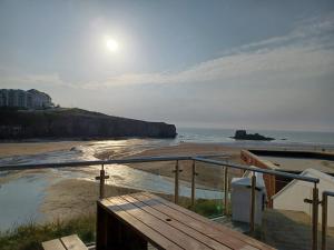 a view of a beach with the sun rising over the ocean at Cosy Perranporth caravan, Cornwall in Perranzabuloe