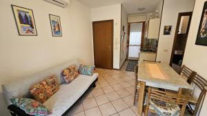 a living room with a couch and a table at Villaggio Tirreno appartamento 02 in Rosolina Mare +6 photos