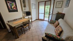 a living room with a couch and a table at Villaggio Tirreno appartamento 02 in Rosolina Mare