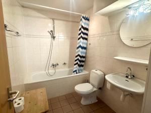 a bathroom with a toilet and a sink and a shower at Appartement Badhotel 324 in Callantsoog +4 photos