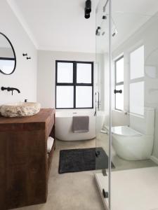a bathroom with a glass shower and a tub and a sink at Breedekloof Kajuit in Romansrivier +34 photos
