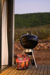 a grill sitting on a porch next to a window at Breedekloof Kajuit in Romansrivier